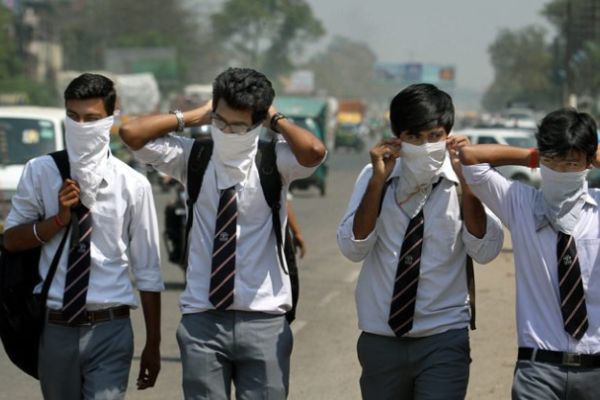 Quattro ragazzi si proteggono dall'inquinamento a New Delhi